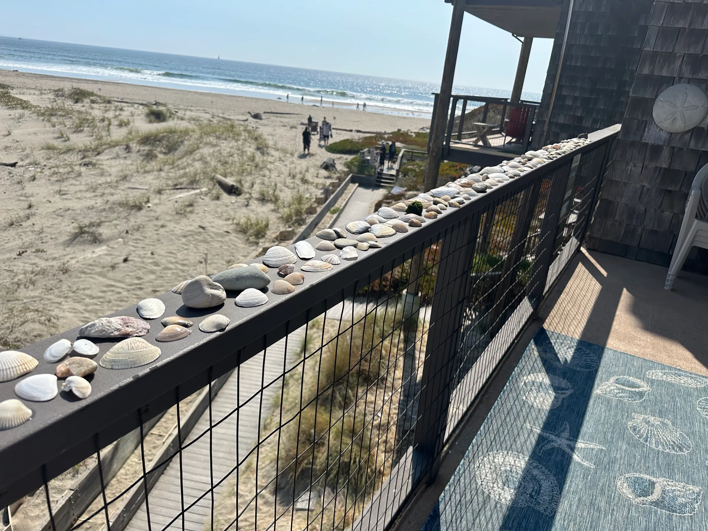 Shells lined along the balcony rail above the beach path