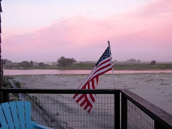 The balcony at dusk, with a flag over the river