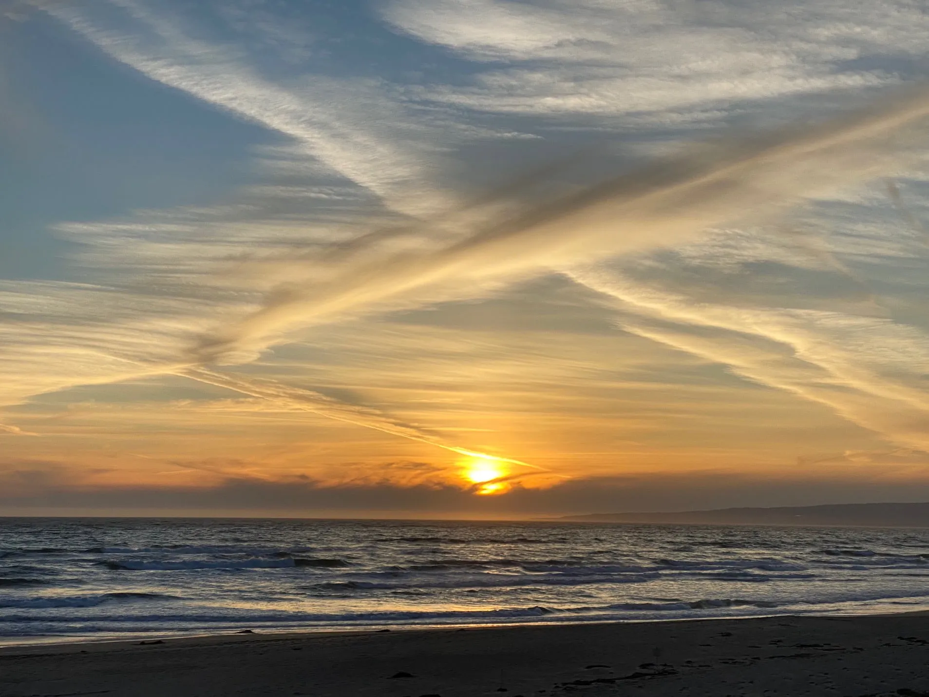 Sunset and vapor trails over the bay