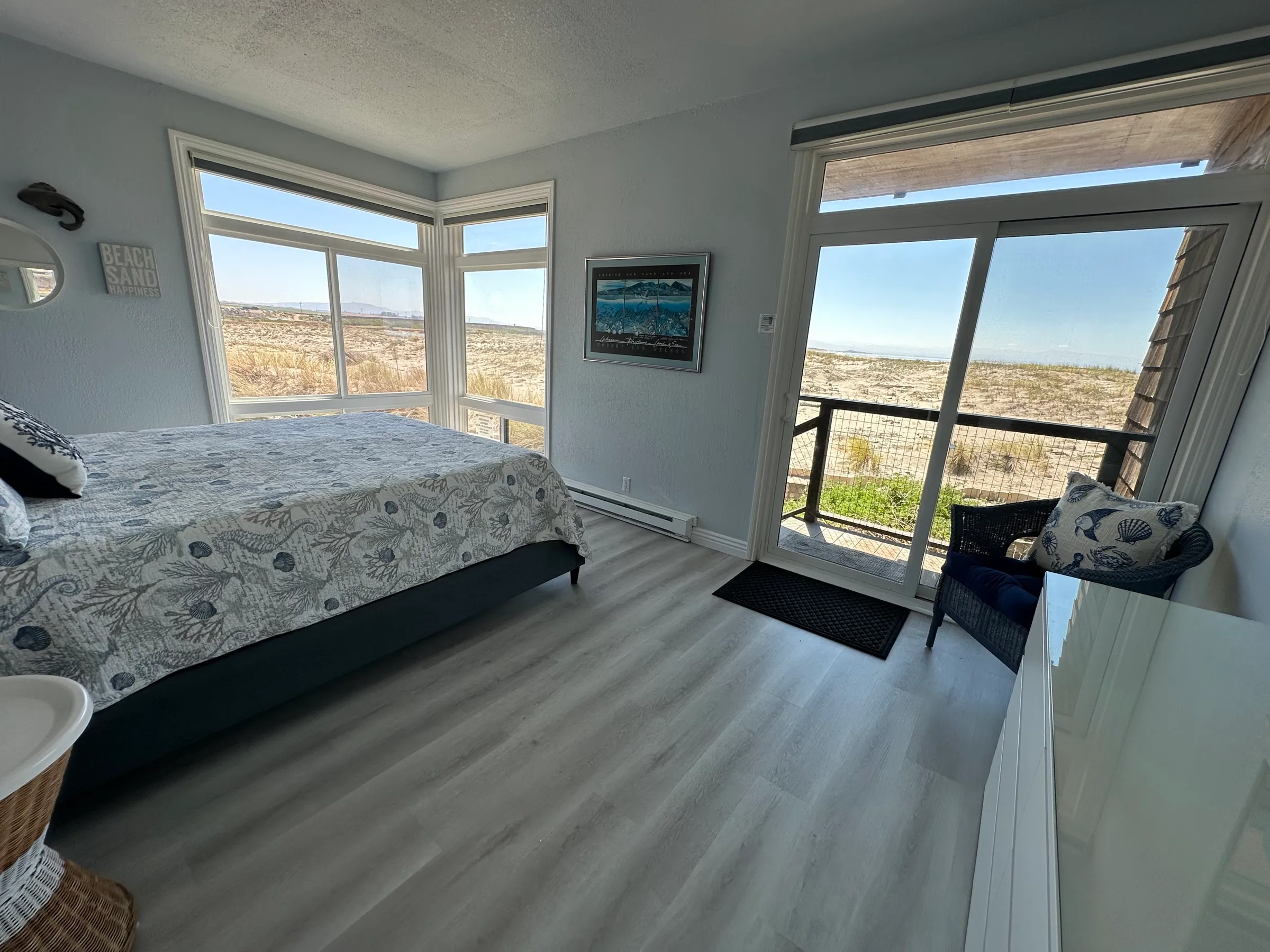 The master bedroom, with corner windows and a slider onto the beach